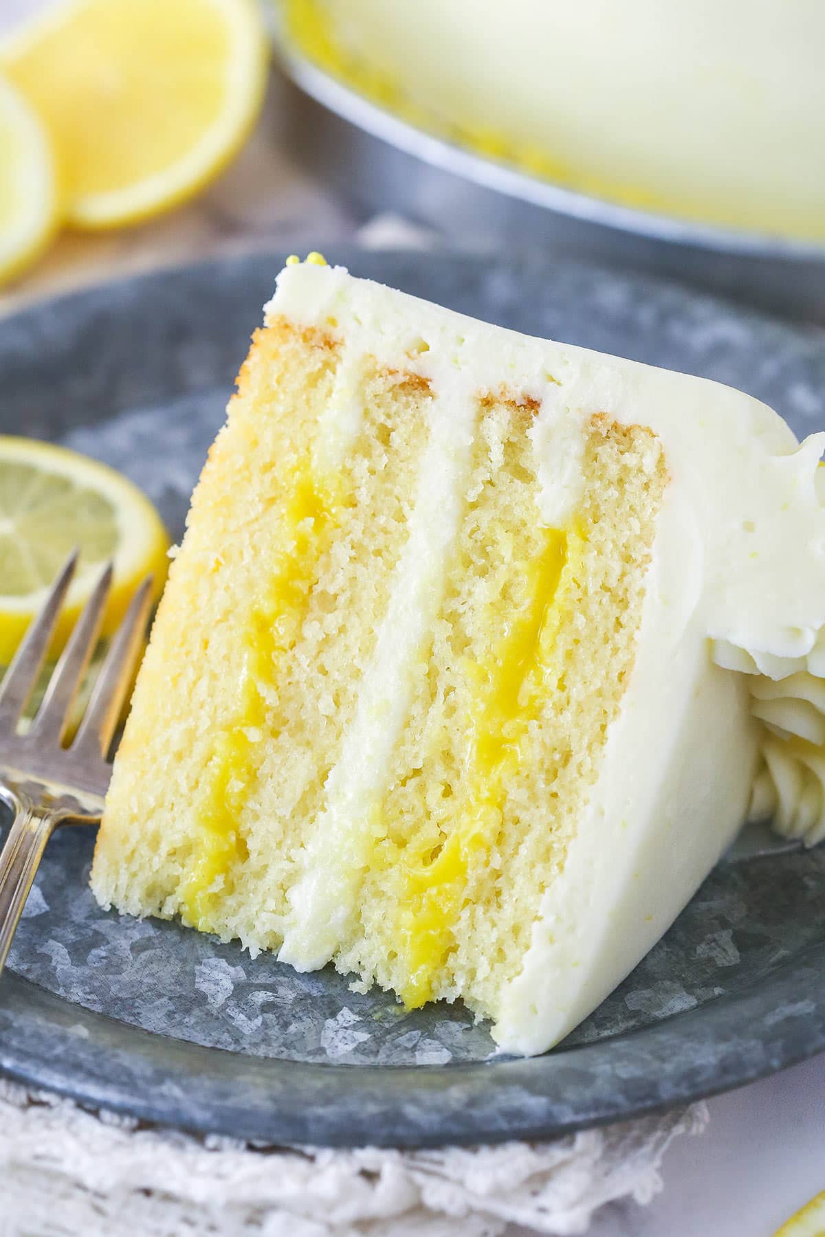 A slice of lemon curd cake on a plate.
