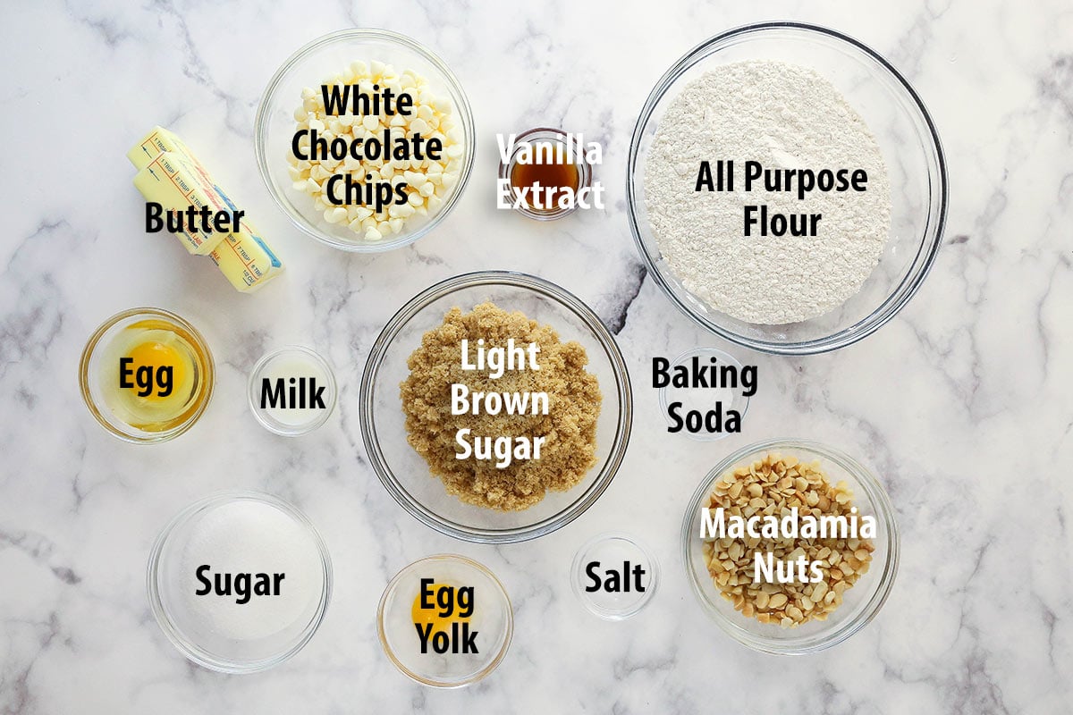Ingredients for white chocolate macadamia nut cookies separated into bowls and labeled.