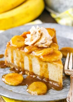 A slice of Bananas Foster Cheesecake next to a silver fork on a gray plate