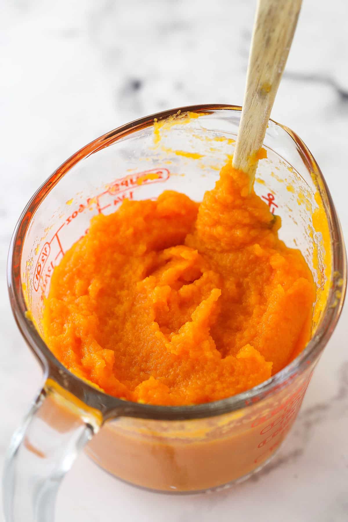 Carrot puree in a measuring cup.