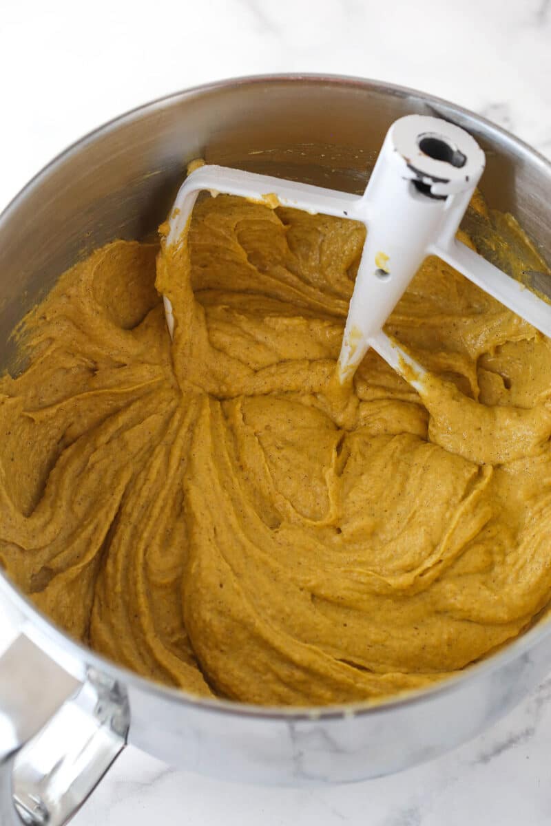 Mixing dry ingredients and carrots puree into carrot cake batter.