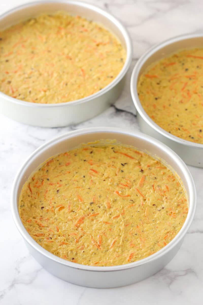 Carrot cake batter in 3 cake pans.