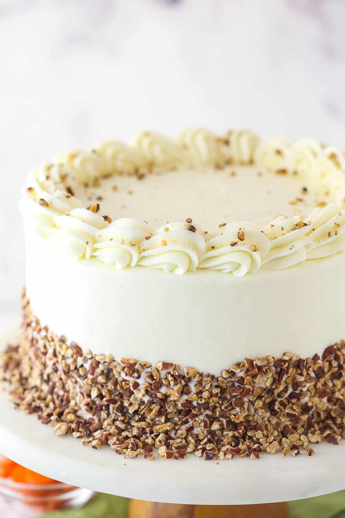 Tilted overhead shot of carrot cake on a cake stand.