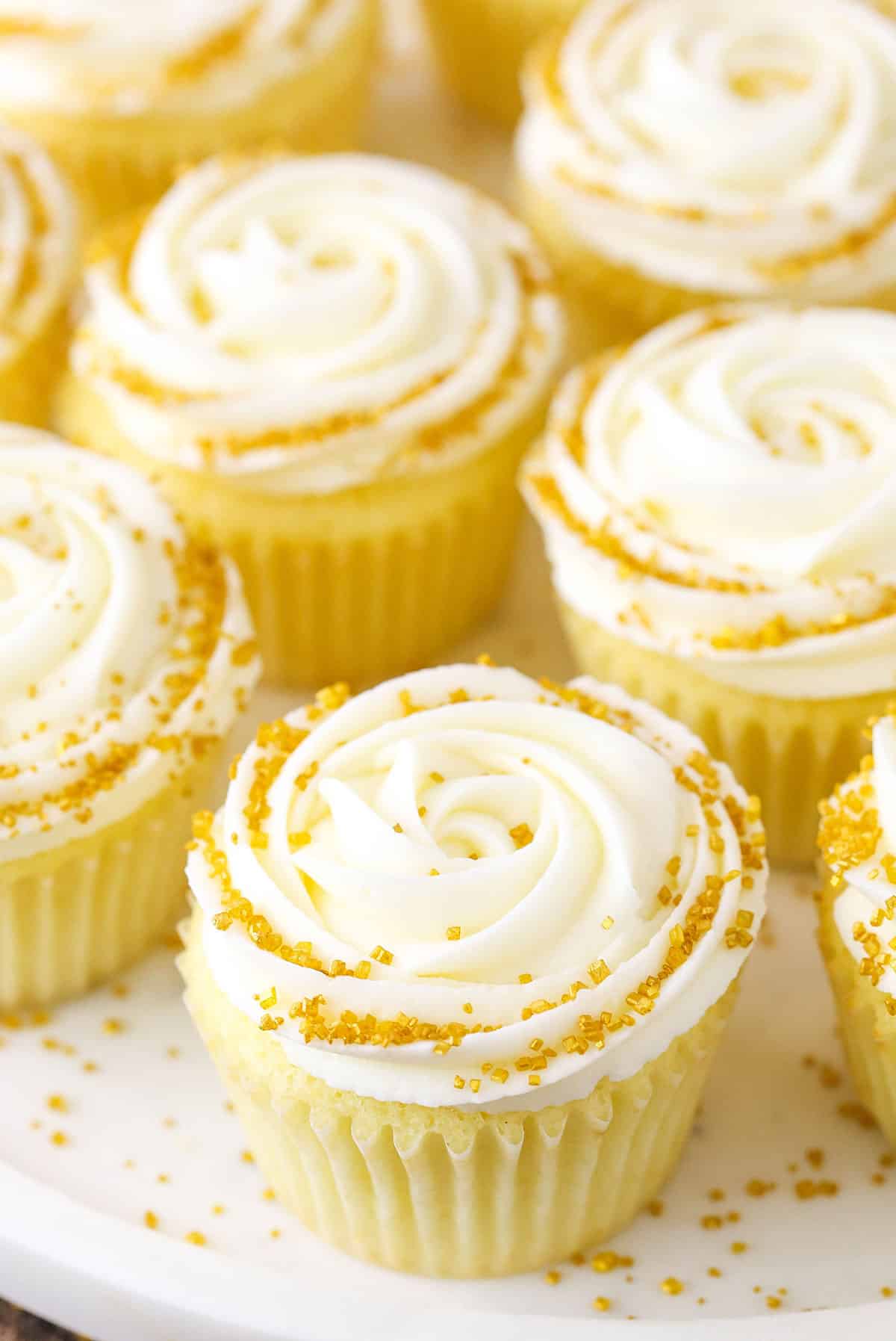 Champagne Cupcakes With Truffle Filling on a white cake stand