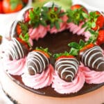 A full Chocolate Covered Strawberry Cheesecake on a white cake stand