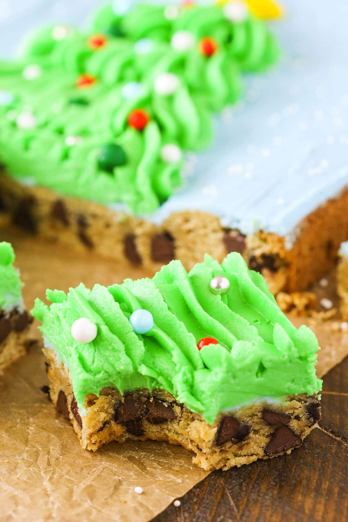 A square slice of Christmas Tree Chocolate Chip Cookie Cake with a bite removed