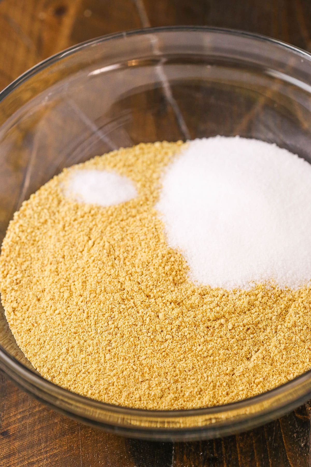 Easy Graham Cracker Crust in a clear glass bowl on a wooden table