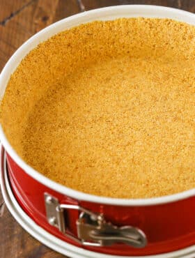 Easy Graham Cracker Crust in a red springform pan on a wooden table