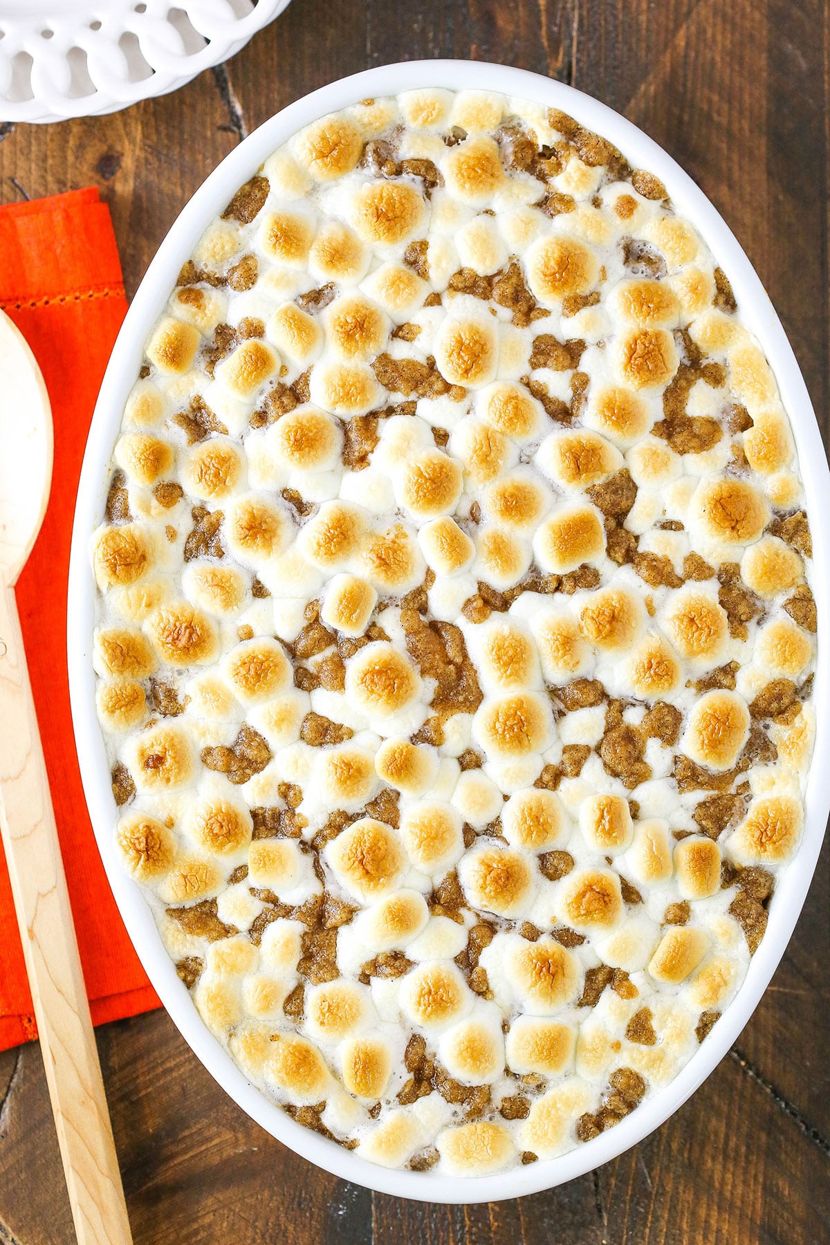 Overhead view of Loaded Sweet Potatoes in a white oval casserole dish on a wooden table