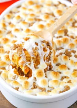 A scoop of Loaded Sweet Potatoes being taken with a wooden spoon