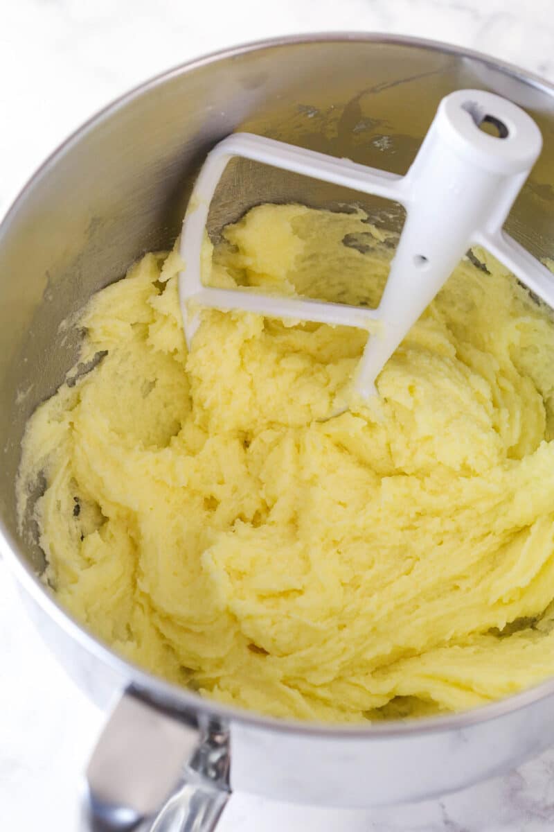 Adding eggs to wet ingredients for pumpkin bread.