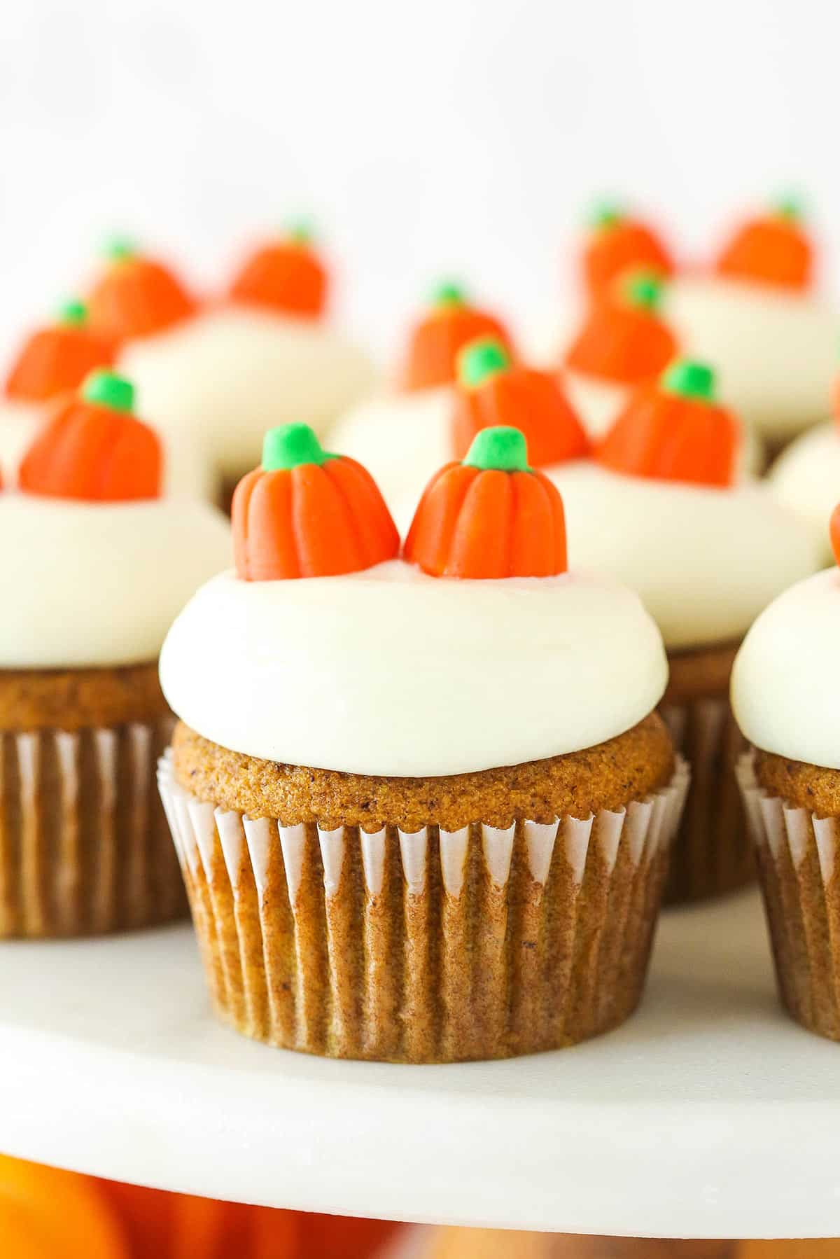 Closeup of pumpkin cupcakes on a cake stand.