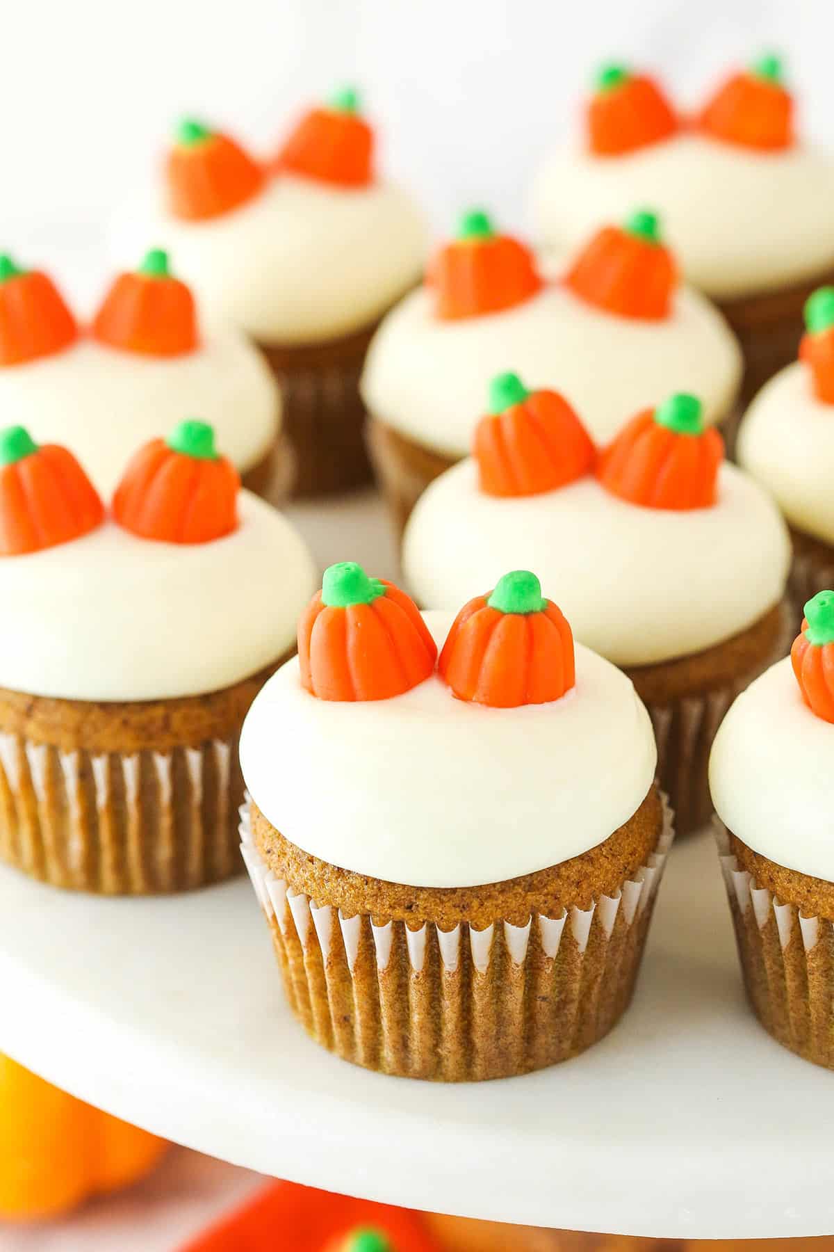 Pumpkin cupcakes on a cake stand.