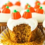 A pumpkin cupcake with a bite taken out of it.