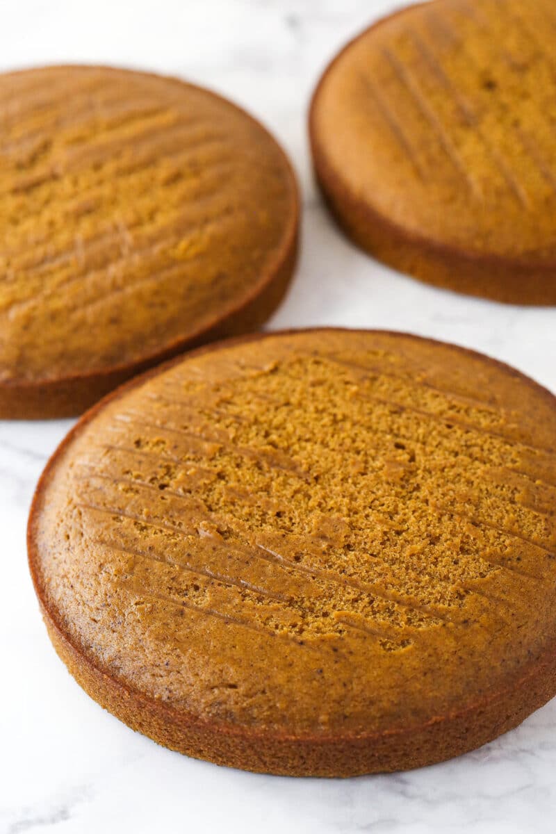 3 layers of pumpkin cake on a marble counter.