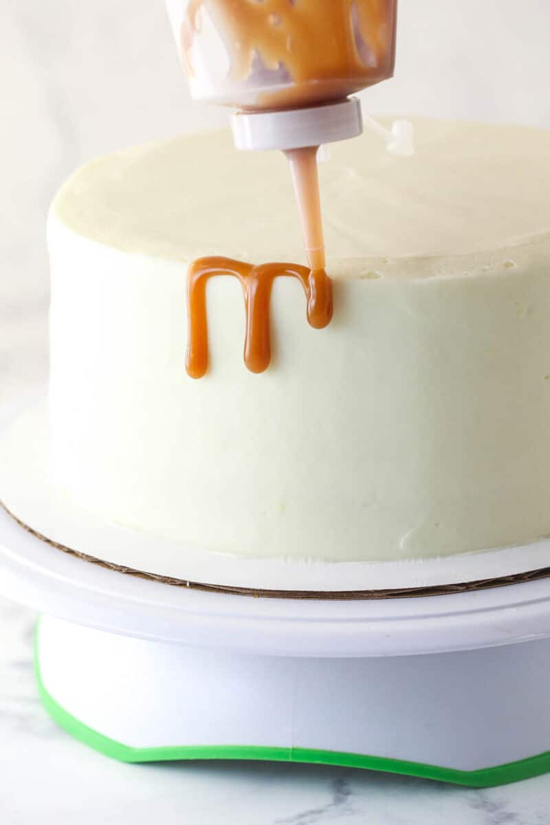 Adding caramel drips to pumpkin layer cake.