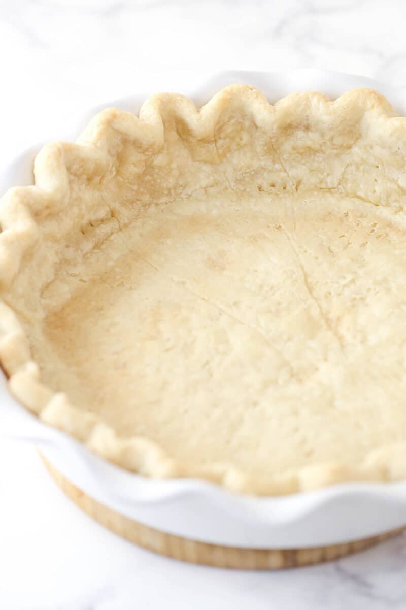 This classic pumpkin pie recipe is so easy and delicious! Full of pumpkin flavor and fall spices, it's the perfect Thanksgiving dessert. Pie crust in a pie dish after blind baking.