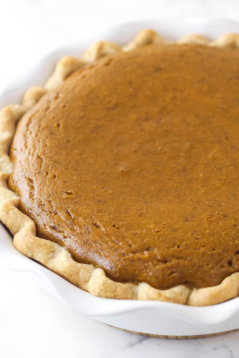 This classic pumpkin pie recipe is so easy and delicious! Full of pumpkin flavor and fall spices, it's the perfect Thanksgiving dessert. Closeup of pumpkin pie.