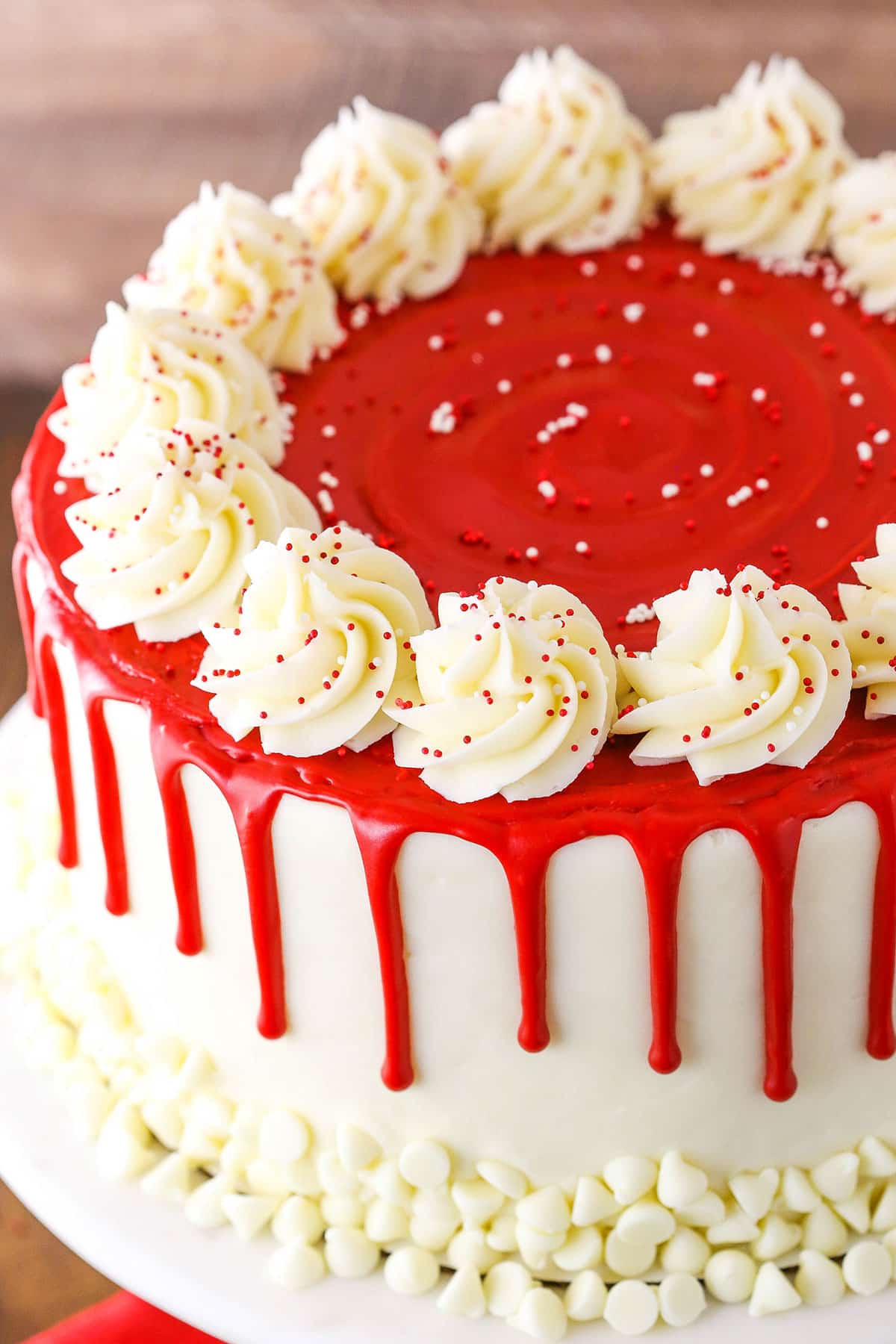 Overhead view of a full Red Velvet Cheesecake Cake on a white cake stand