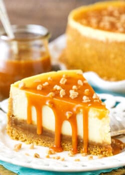 A slice of Salted Caramel Cheesecake next to a fork on a white plate