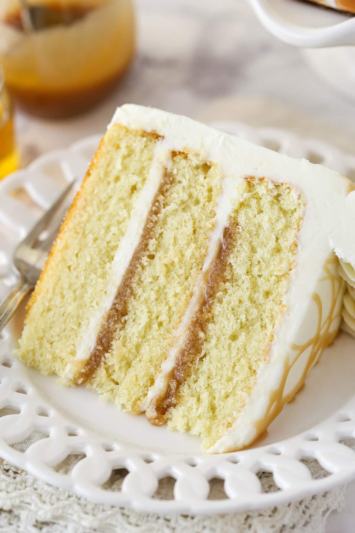 A slice of vanilla bourbon layer cake on a plate.