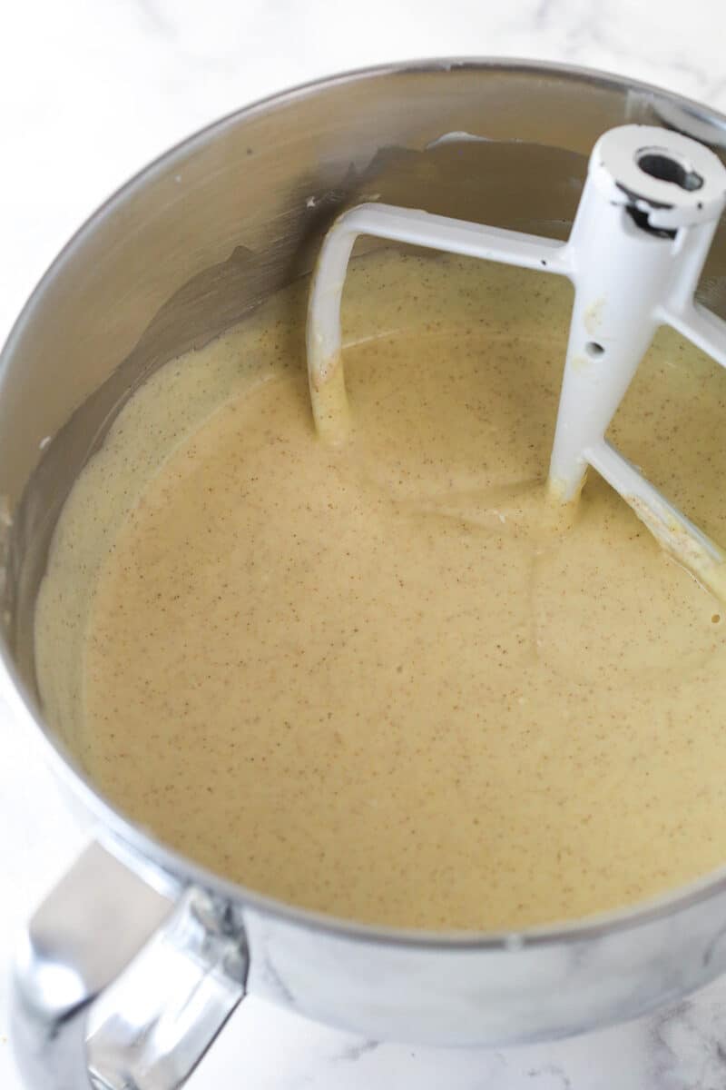 Mixing eggs into cinnamon cheesecake batter.