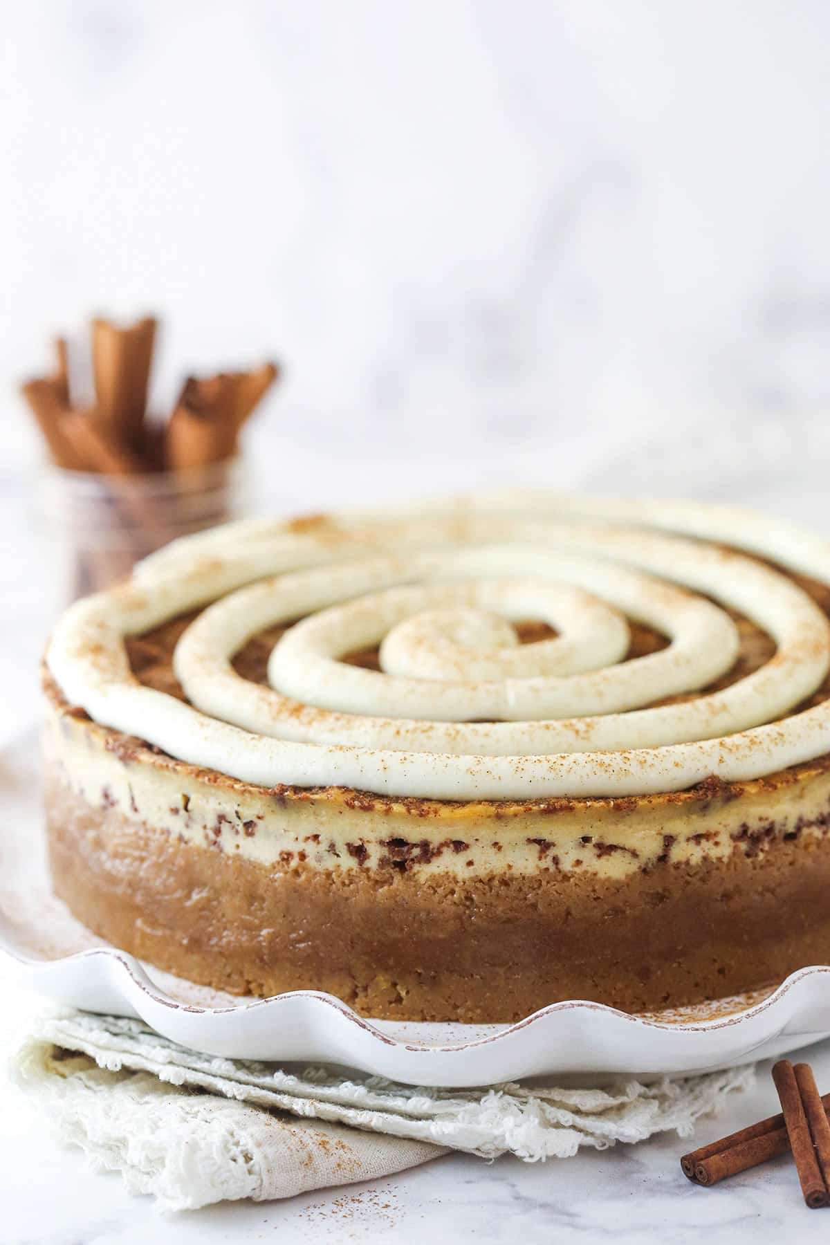 Cinnamon roll cheesecake on a serving plate.