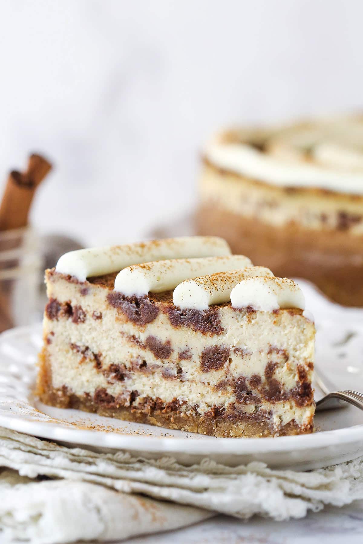 A slice of cinnamon roll cheesecake on a plate.