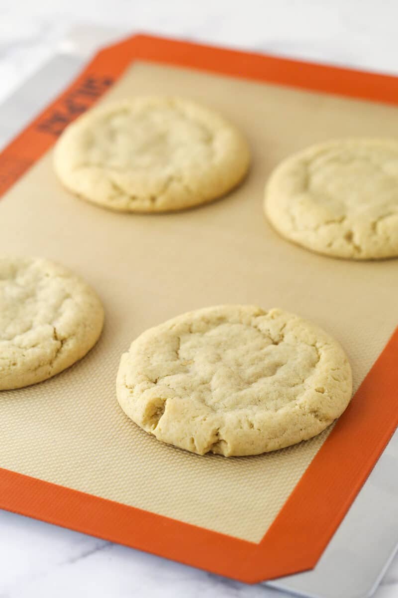 4 baked apple crumb cookies on a baking mat.