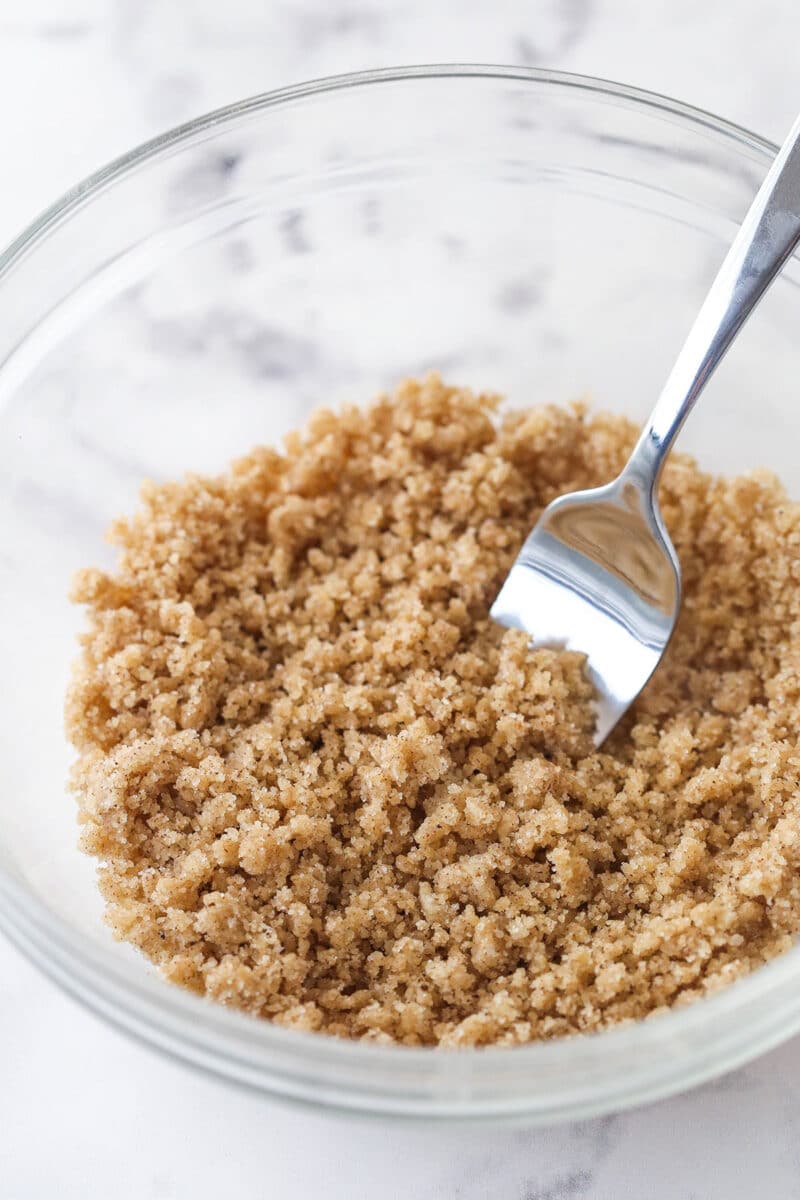 Fork in a clear bowl of streusel topping.