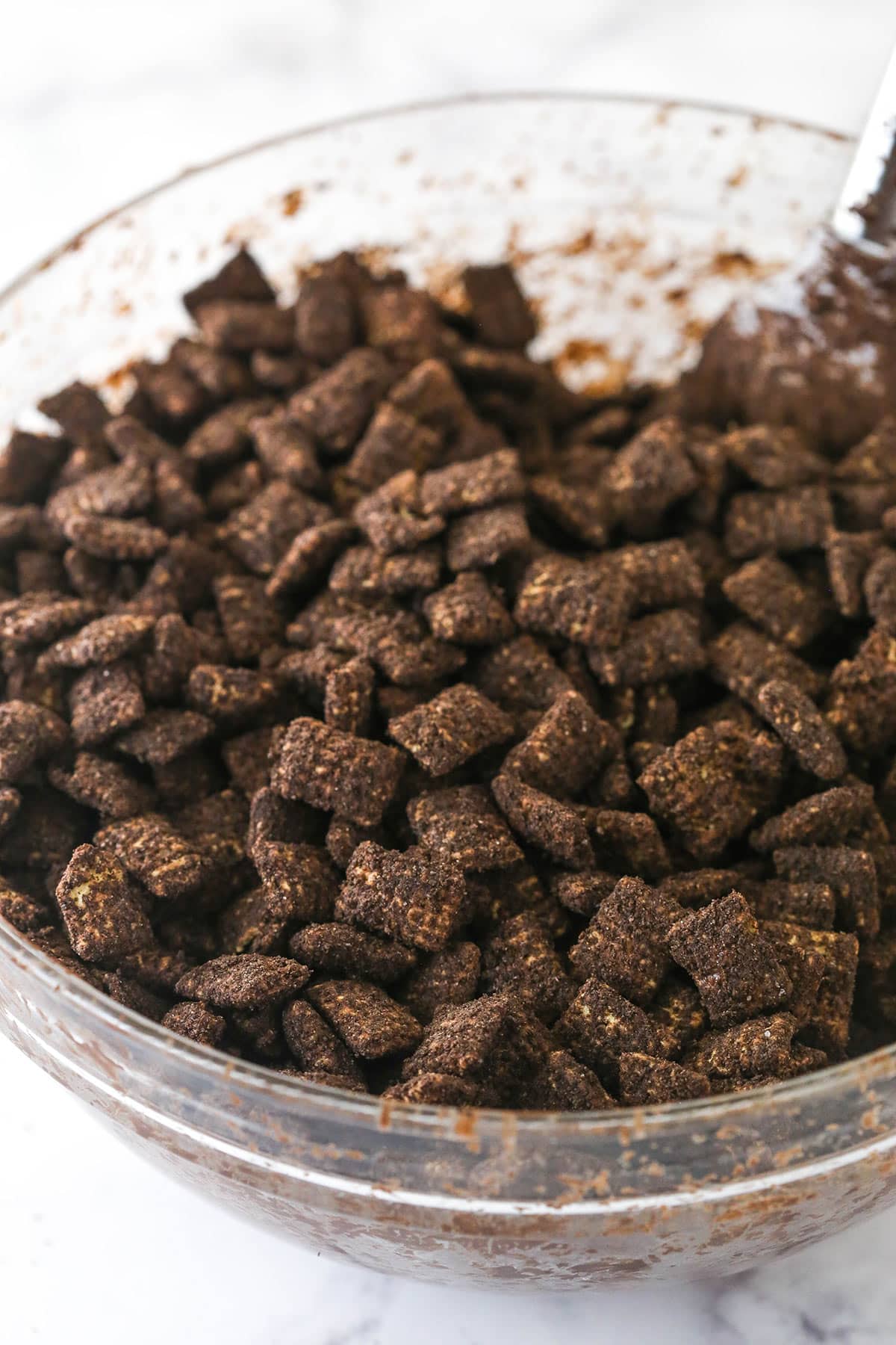 Mixing bowl with chex cereal and chocolate to make Dirt and Worms Puppy Chow.