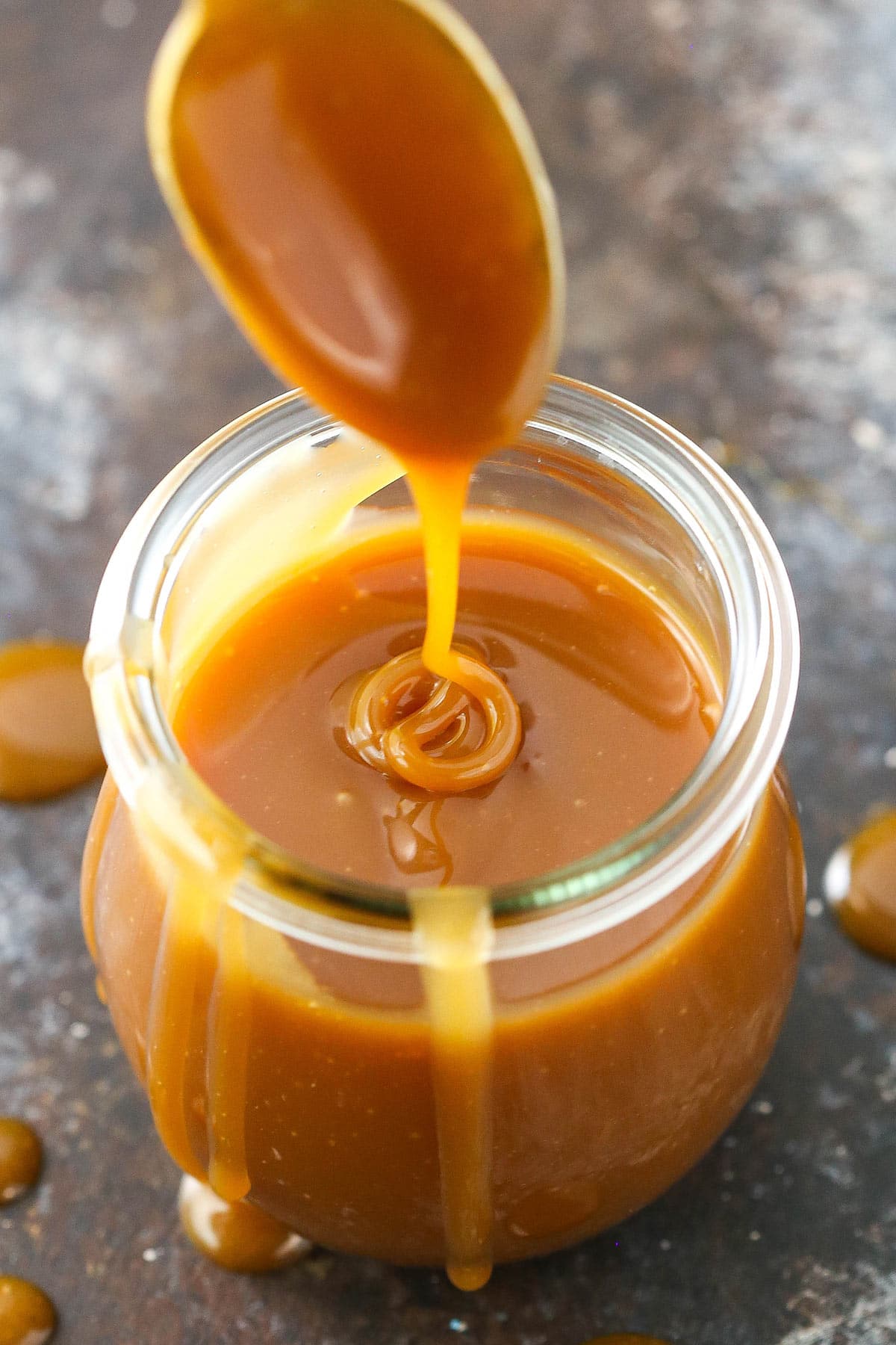 Overhead of drizzling caramel sauce into a jar.