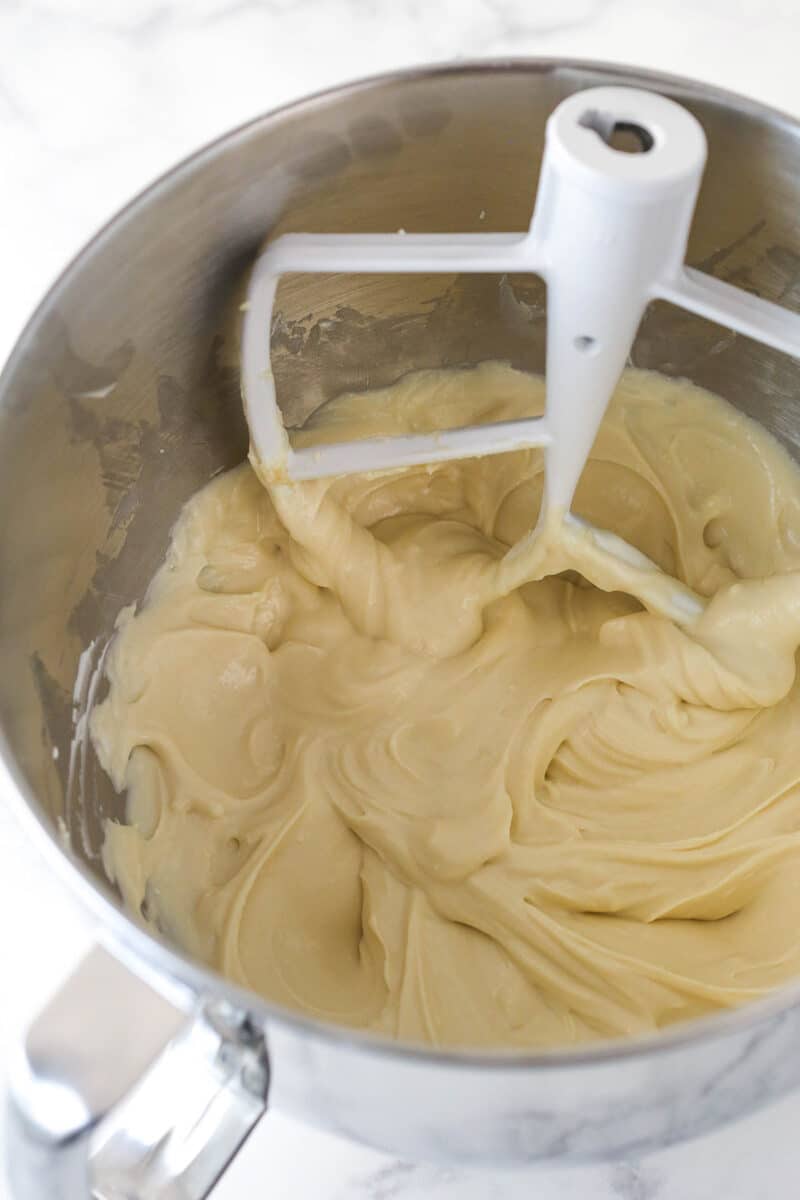 Mixing sour cream and vanilla into cheesecake batter.