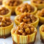 Mini caramel apple cheesecakes on a serving platter.