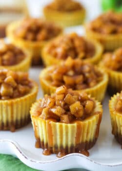 Mini caramel apple cheesecakes on a serving platter.