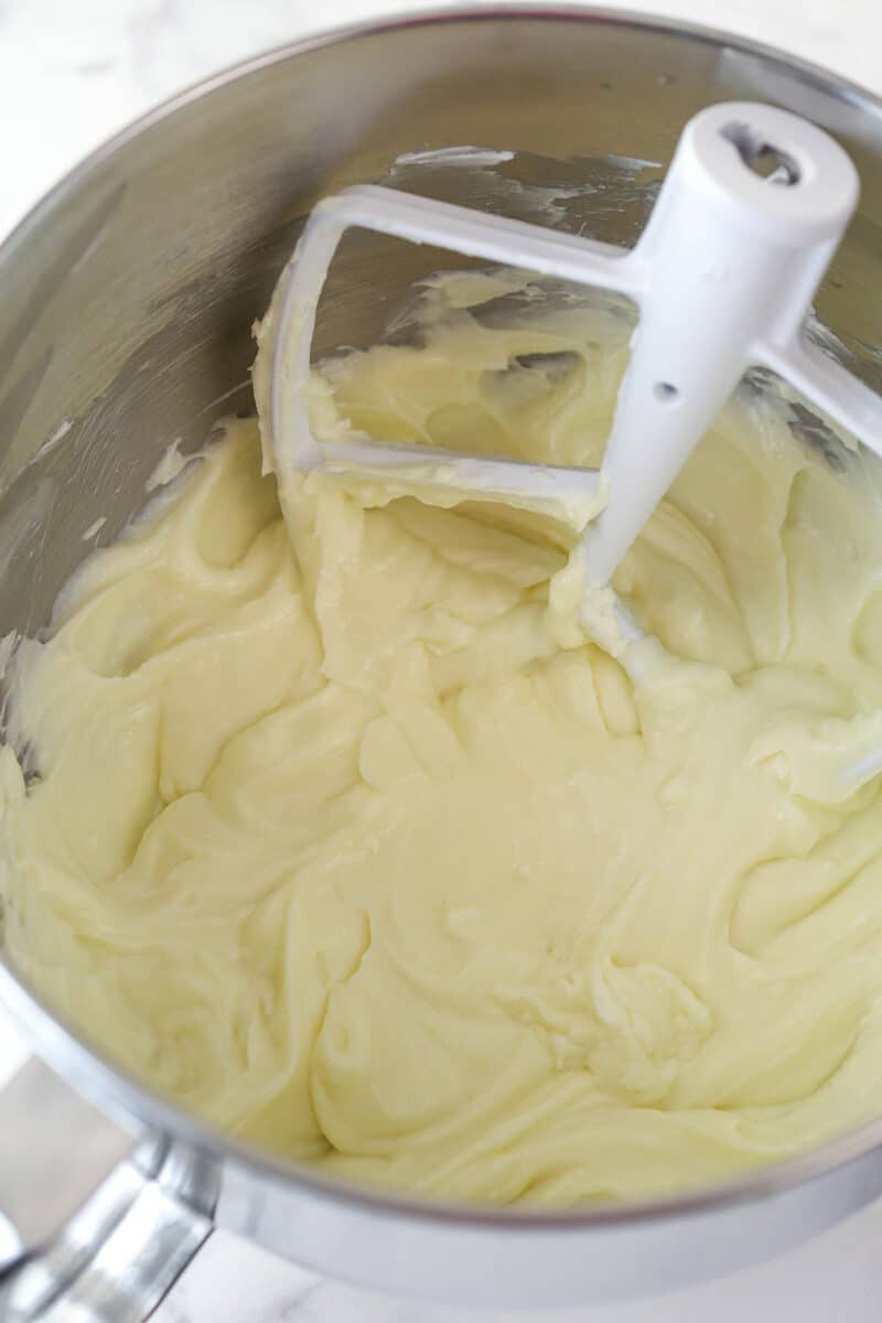 Beating together cream cheese, sugar, and flour for cheesecake.