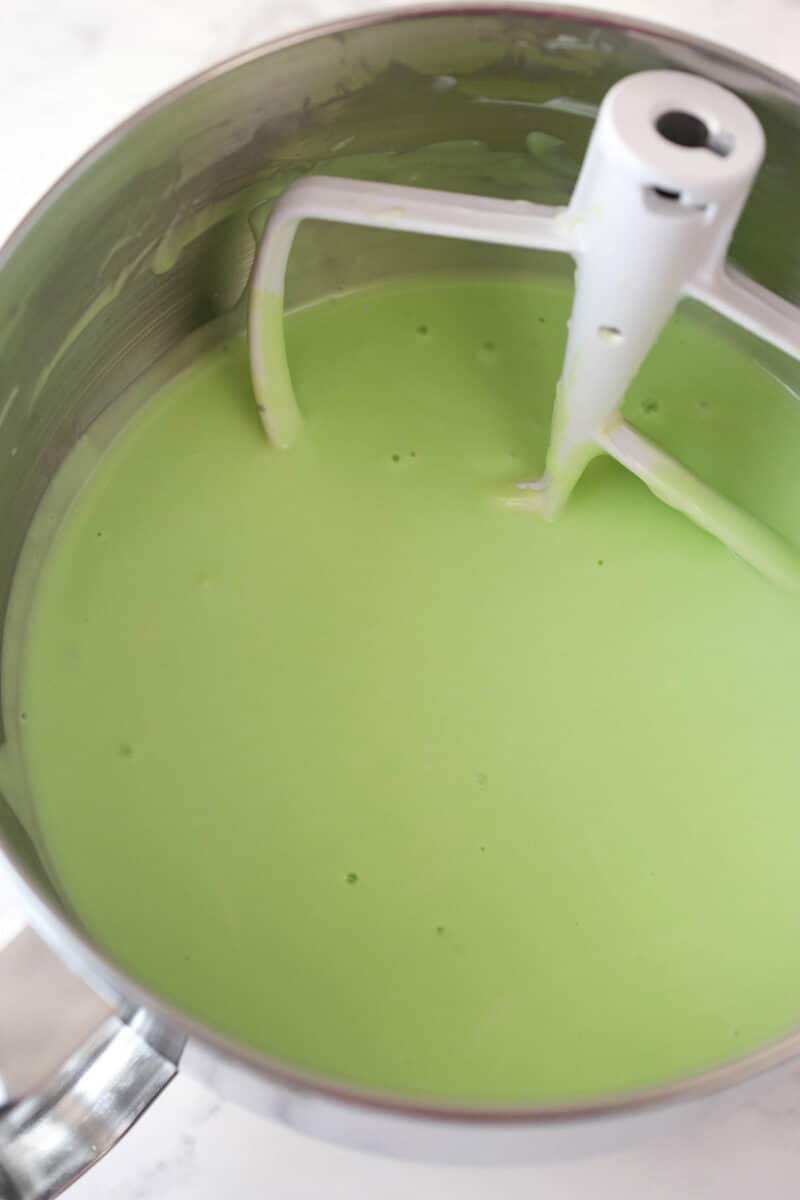 Mixing the eggs and the green gel icing into mint cheesecake batter.