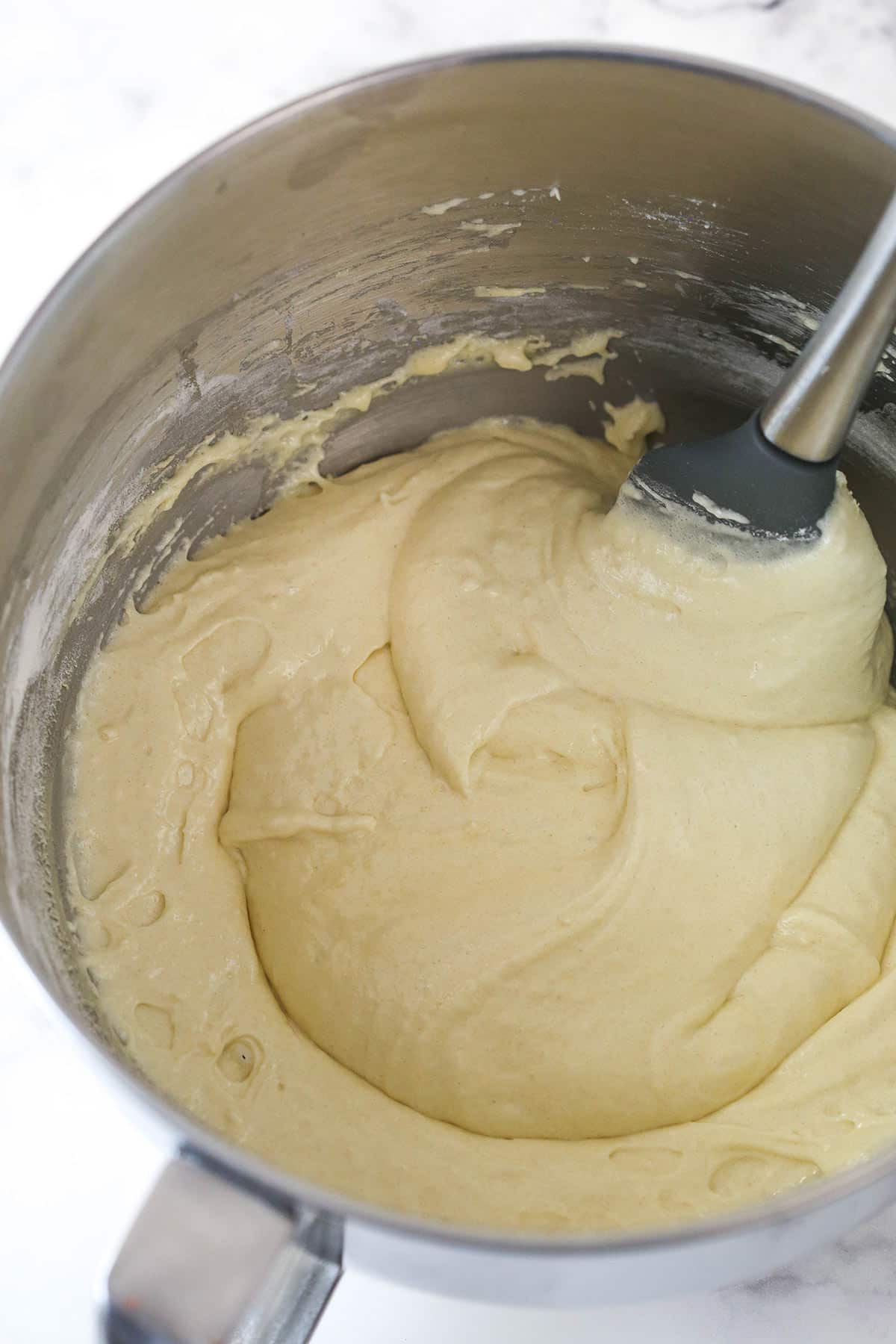 Gradually folding dry ingredients into whipped eggs, sugar, and vanilla.