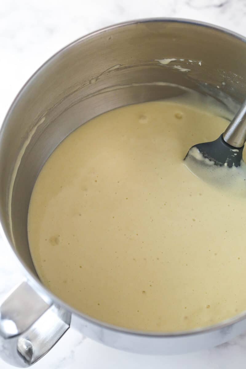 Folding hot milk and melted butter into cake batter.