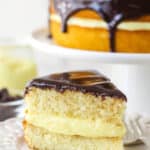 A slice of Boston cream pie on a plate with a fork.