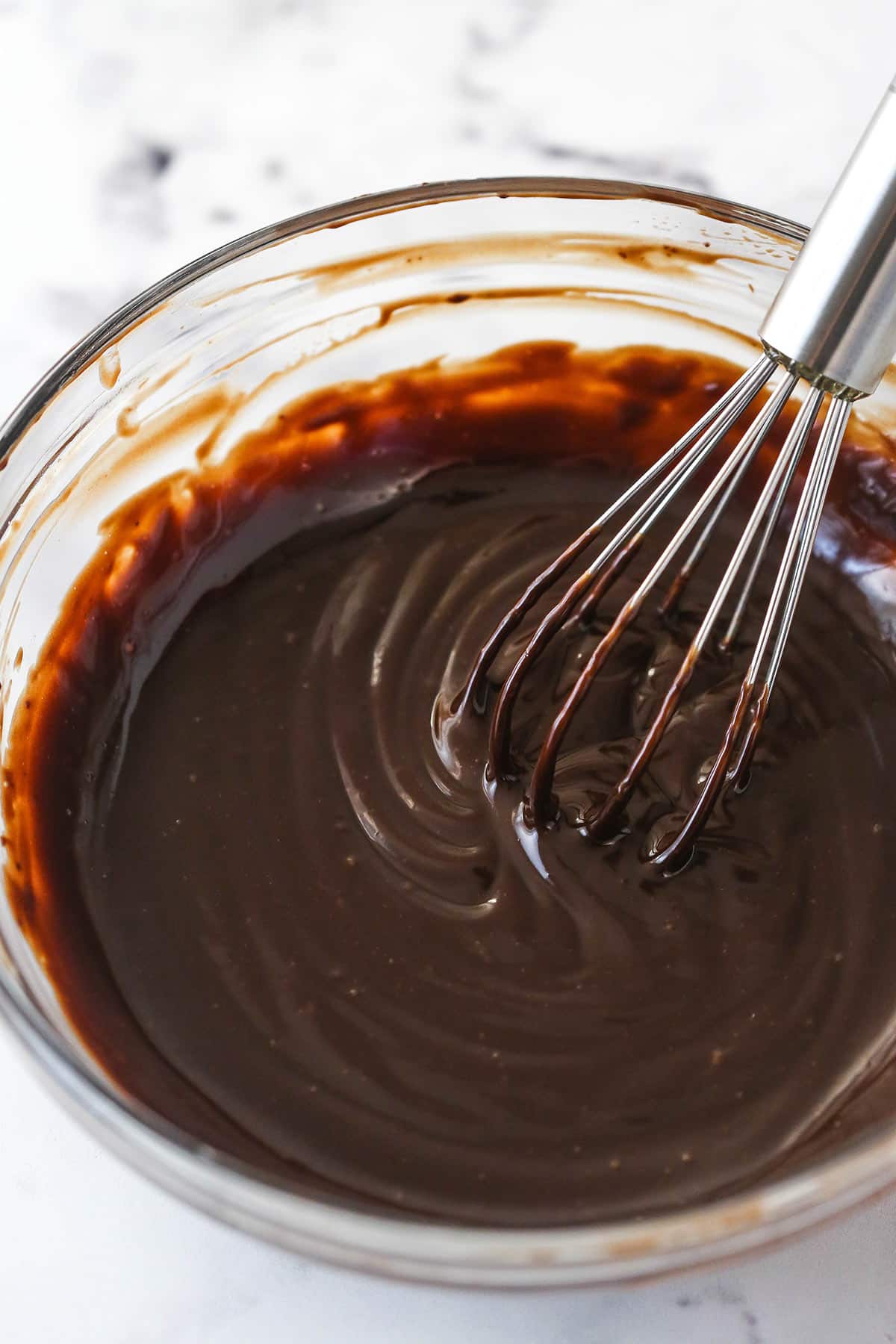 Whisking chocolate ganache in a bowl.