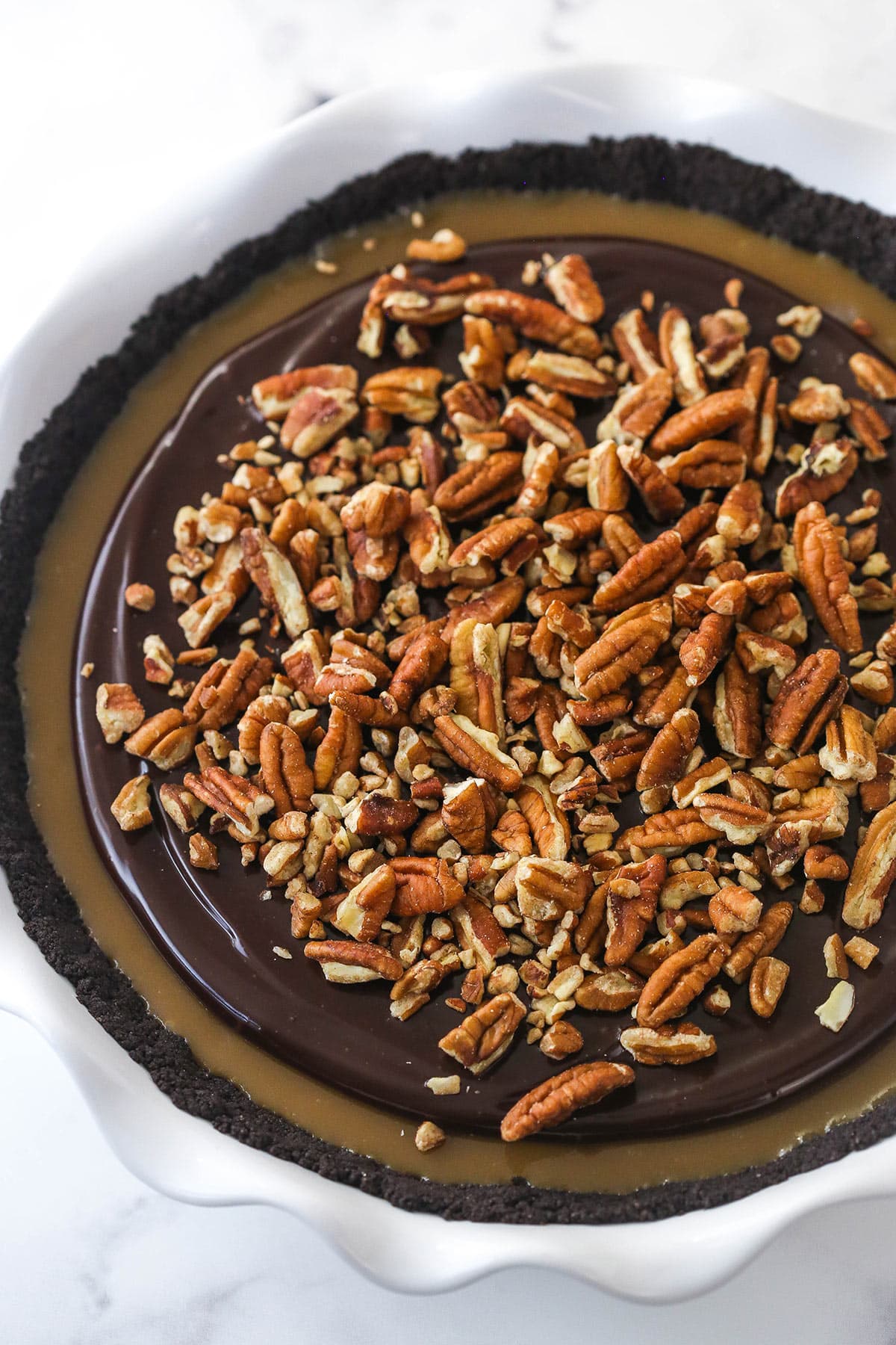 Overhead image of caramel turtle pie in a pie dish.