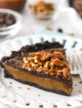 A slice of caramel turtle pie on a plate.