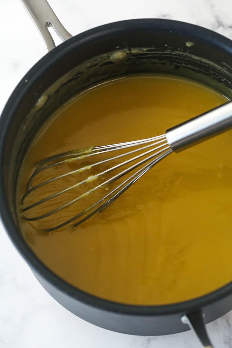 Cooking evaporated milk, vanilla extract, sugar, and butter for coconut pecan cake filling.