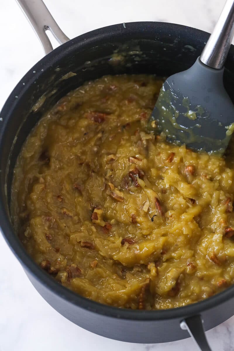 Stirring shredded coconut and chopped toasted pecans into German chocolate cake filling.