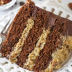 A slice of german chocolate cake on a plate with a fork.