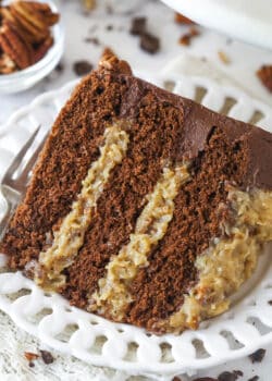 A slice of german chocolate cake on a plate with a fork.