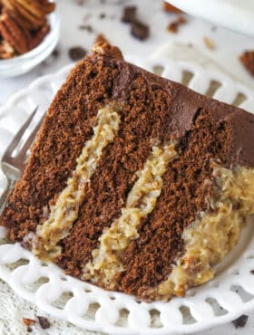 A slice of german chocolate cake on a plate with a fork.