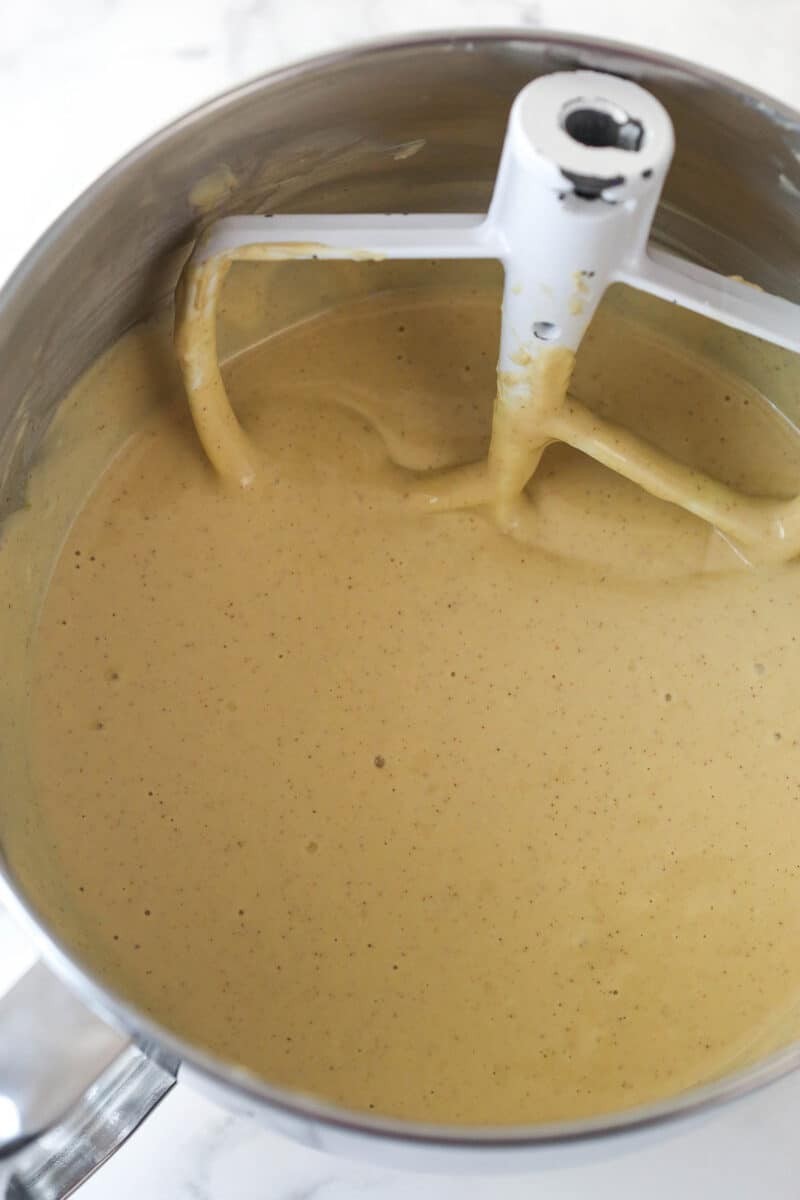 Mixing eggs into cheesecake batter.