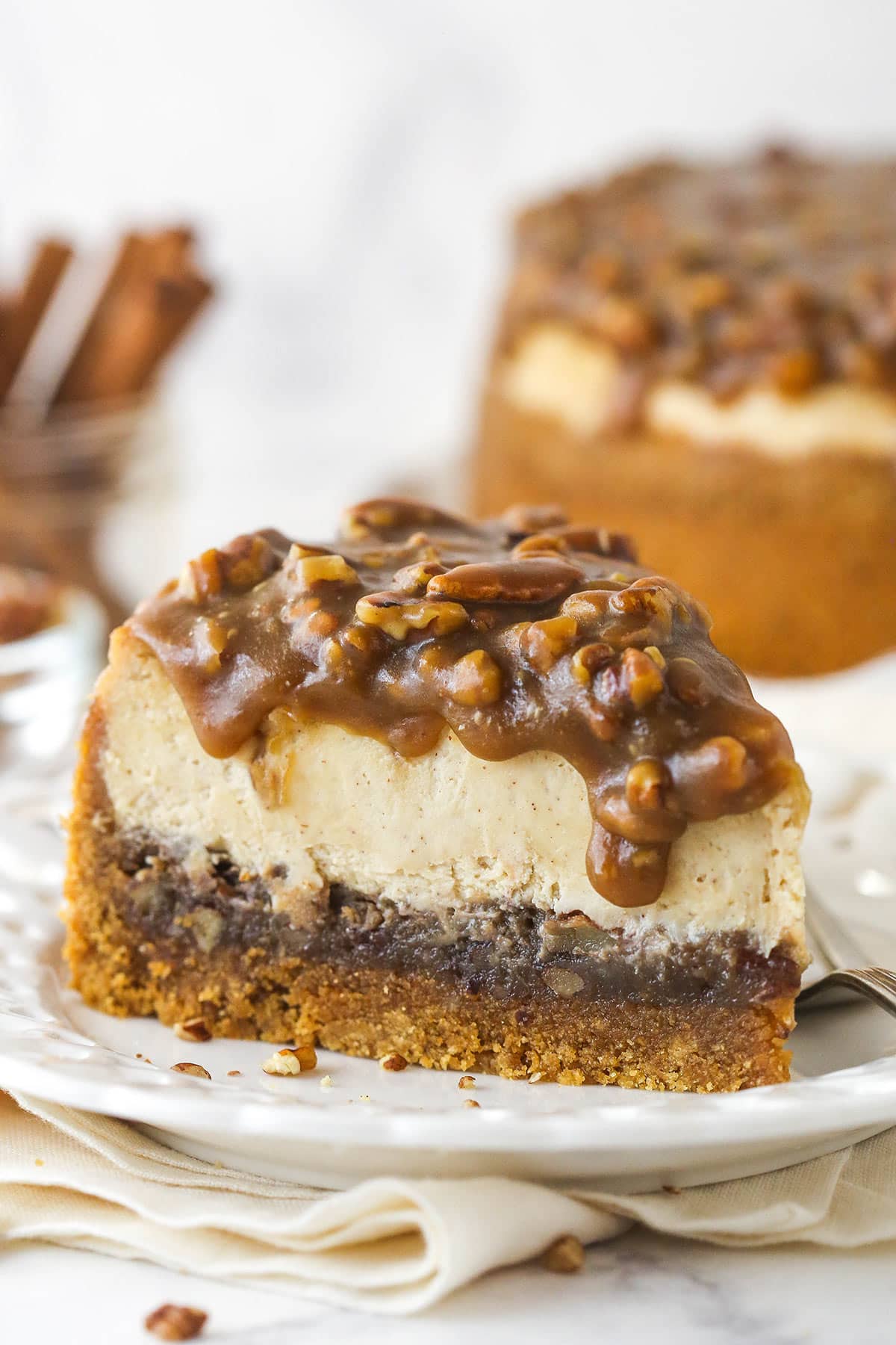 A slice of pecan pie cheesecake on a plate.